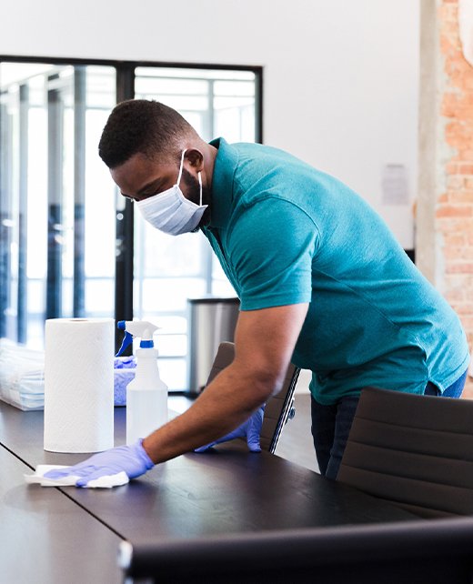 Afro-Latino woman cleans the windows of an office she works for